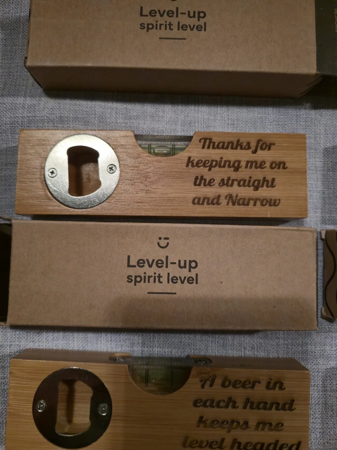 Two real engraved bottle openers with spirit level and messages